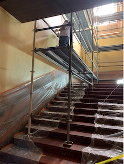 facilities worker on scaffolding working on powell restoration